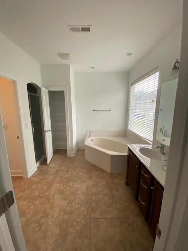 bathroom featuring vanity and a tub to relax in