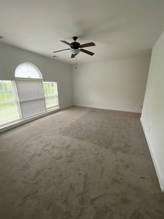 carpeted spare room with ceiling fan