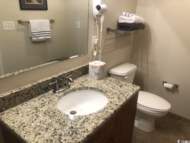 bathroom with tile flooring, toilet, and vanity