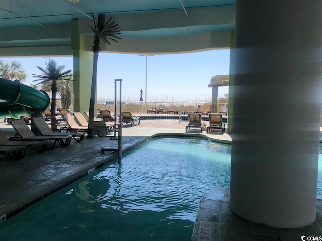 view of swimming pool with a water slide and a patio area