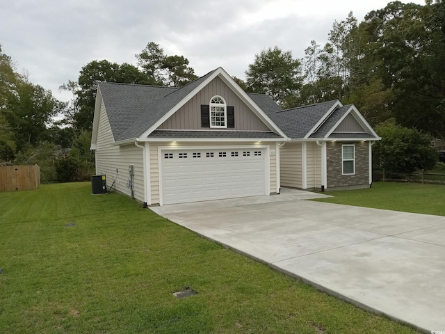 view of front of property featuring a front lawn, a garage, and cooling unit