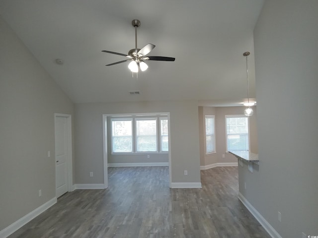 empty room featuring ceiling fan, lofted ceiling, and dark wood-type flooring