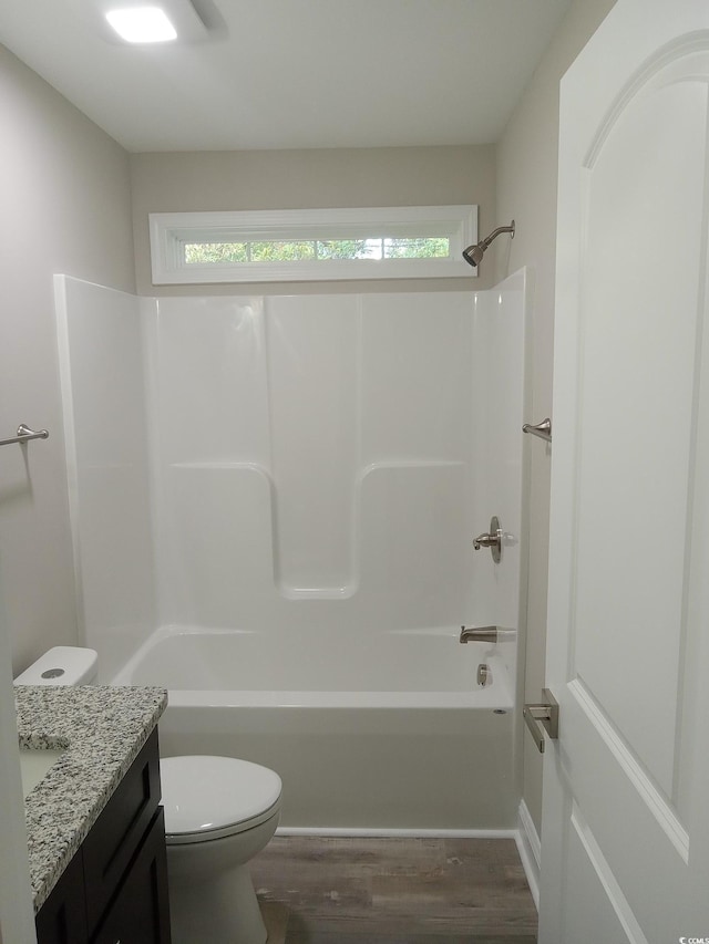 full bathroom featuring vanity, hardwood / wood-style flooring, toilet, and a healthy amount of sunlight