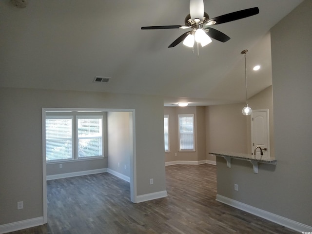 unfurnished living room with dark hardwood / wood-style floors, ceiling fan, sink, and vaulted ceiling