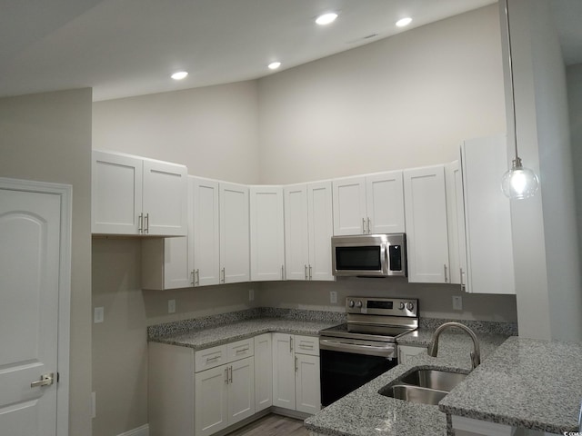 kitchen with white cabinets, sink, light stone countertops, appliances with stainless steel finishes, and decorative light fixtures