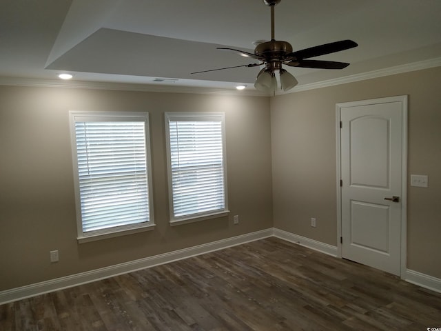 spare room with a healthy amount of sunlight, ornamental molding, and dark wood-type flooring