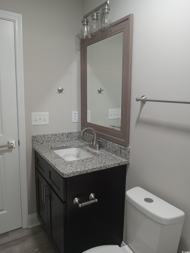 bathroom featuring hardwood / wood-style floors, vanity, and toilet