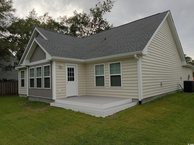 back of house with a lawn and central AC unit