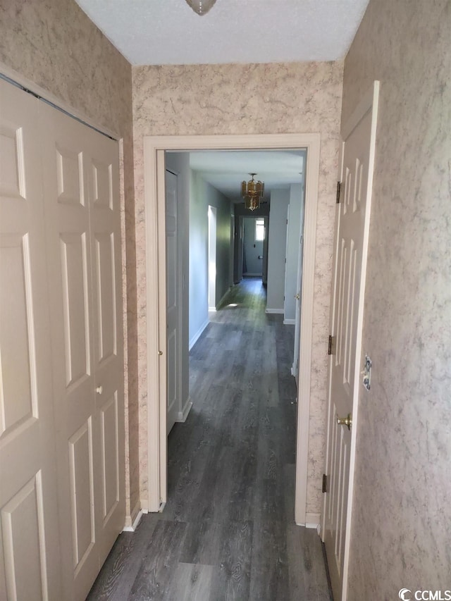 hall featuring dark hardwood / wood-style floors and a chandelier