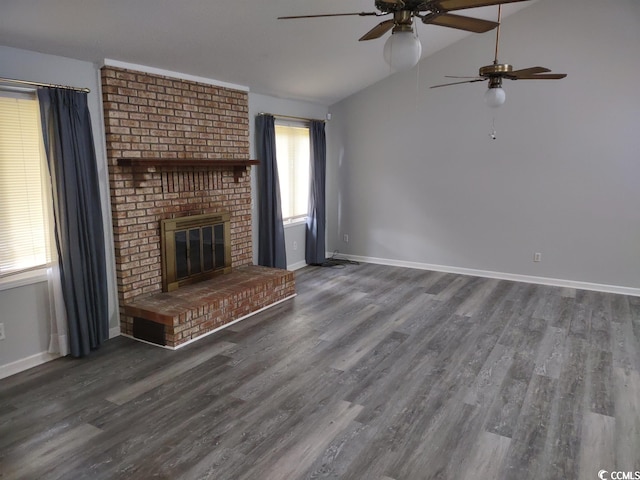 unfurnished living room with vaulted ceiling, ceiling fan, dark wood-type flooring, and a brick fireplace