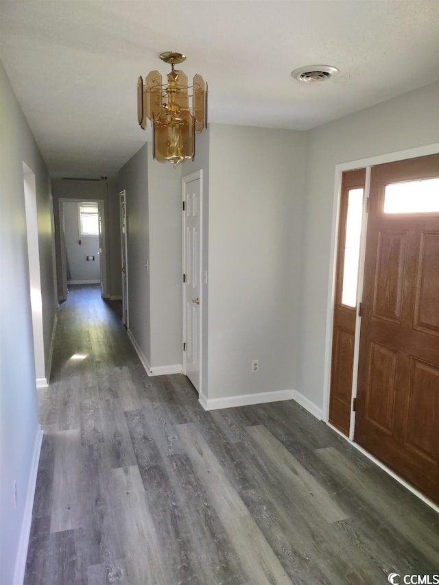 entryway with a chandelier and dark wood-type flooring