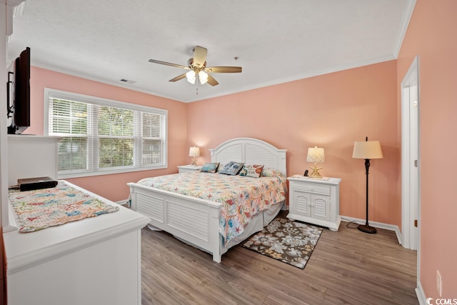 bedroom with ornamental molding, ceiling fan, and light wood-type flooring