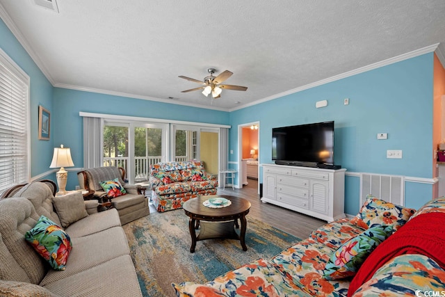 living room featuring ceiling fan, a textured ceiling, crown molding, and dark wood-type flooring