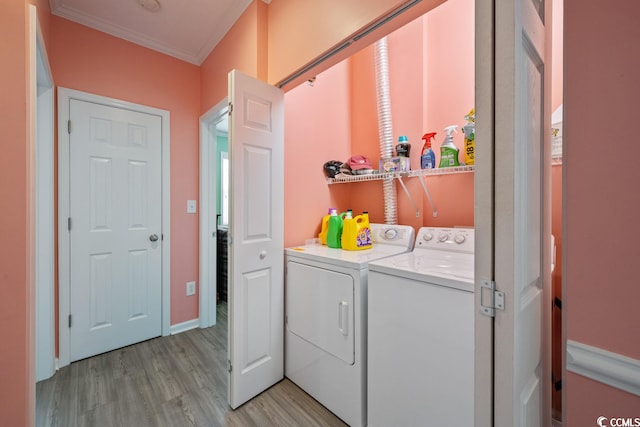 washroom featuring light hardwood / wood-style flooring, crown molding, and washing machine and dryer