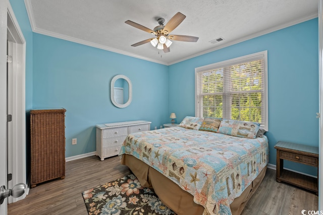 bedroom with ceiling fan, a textured ceiling, crown molding, and dark wood-type flooring