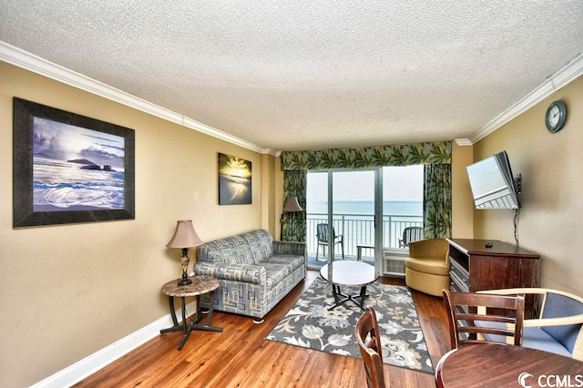 living room featuring hardwood / wood-style flooring, a textured ceiling, and ornamental molding