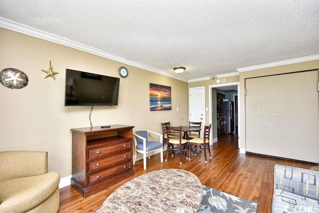 living area with crown molding, a textured ceiling, and hardwood / wood-style flooring