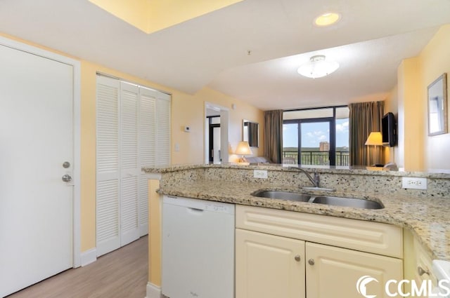 kitchen featuring light stone countertops, light hardwood / wood-style flooring, dishwasher, and sink