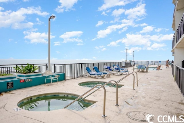 view of pool featuring a patio area and a hot tub