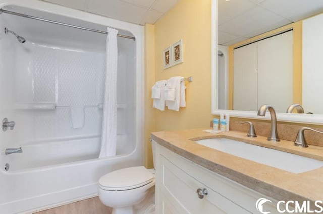 full bathroom featuring toilet, tub / shower combination, vanity, a paneled ceiling, and wood-type flooring