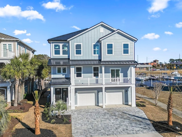 view of front of property with a water view, a balcony, and a garage