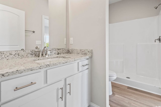 bathroom featuring vanity, hardwood / wood-style floors, toilet, and walk in shower