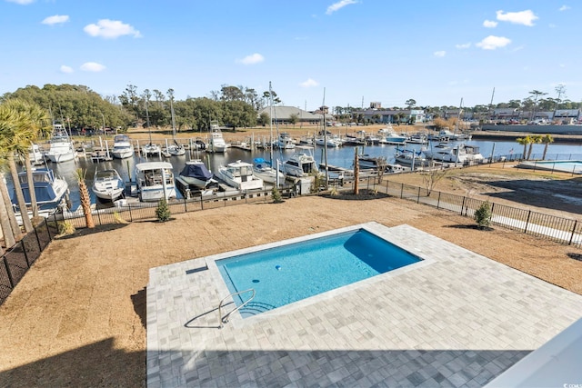 view of pool featuring a water view, a boat dock, and a patio area