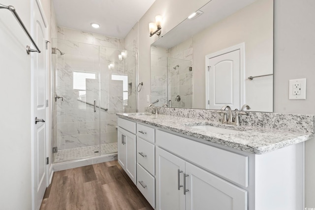 bathroom with hardwood / wood-style flooring, vanity, and a shower with door