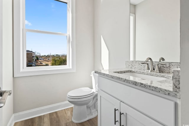 bathroom with hardwood / wood-style flooring, vanity, and toilet