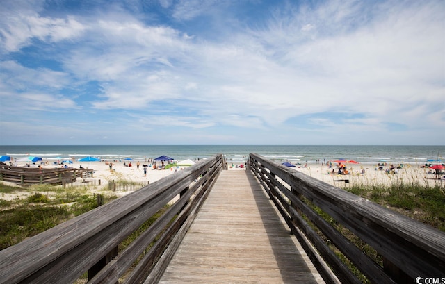 surrounding community with a beach view and a water view