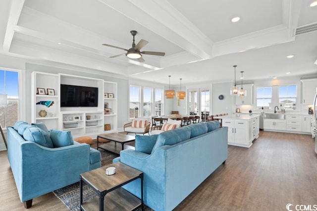 living room featuring sink, ornamental molding, beamed ceiling, light hardwood / wood-style floors, and ceiling fan with notable chandelier