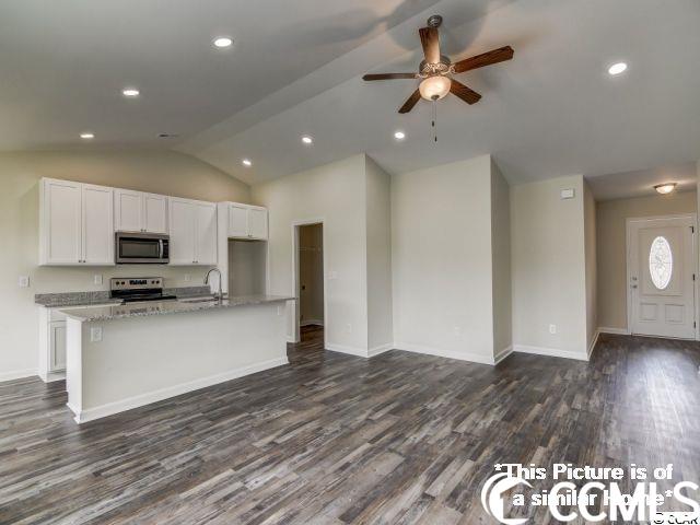 kitchen with wood-type flooring, ceiling fan, range, an island with sink, and lofted ceiling