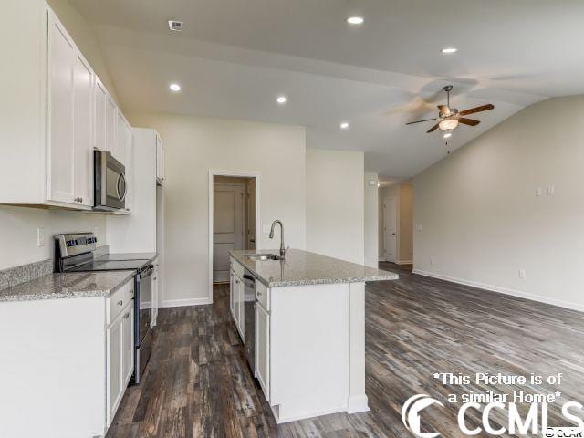 kitchen featuring ceiling fan, stainless steel appliances, white cabinets, an island with sink, and dark wood-type flooring