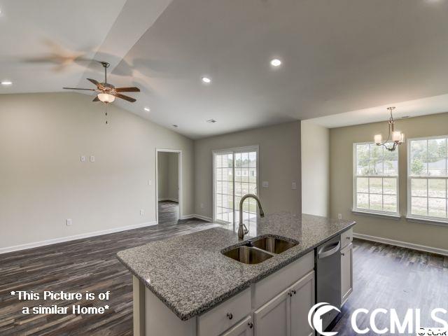 kitchen with lofted ceiling, dishwasher, dark hardwood / wood-style flooring, an island with sink, and sink