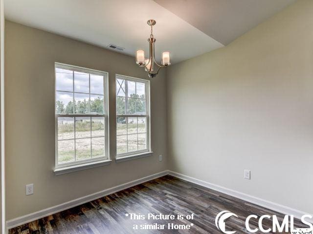 unfurnished room with an inviting chandelier and dark wood-type flooring