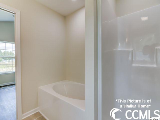 bathroom with a bath and hardwood / wood-style floors