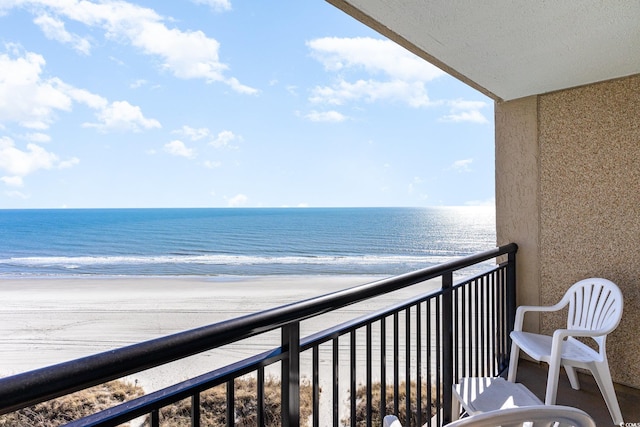 balcony featuring a water view and a view of the beach