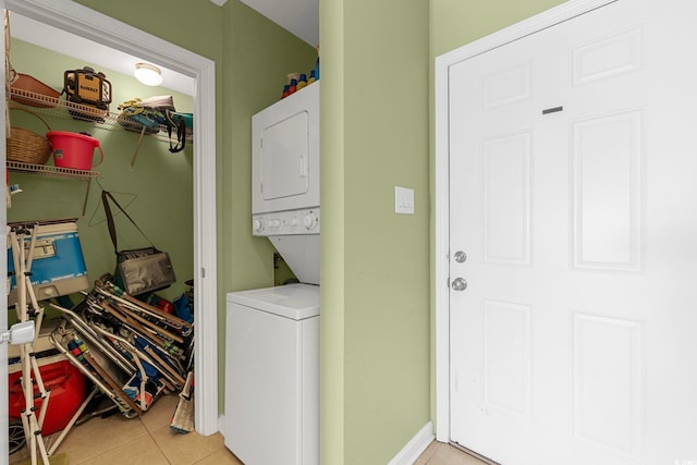 clothes washing area with stacked washer and dryer and light tile patterned floors