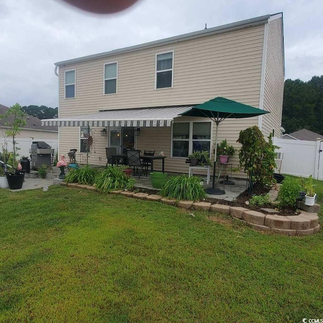 rear view of property featuring a lawn and a patio area