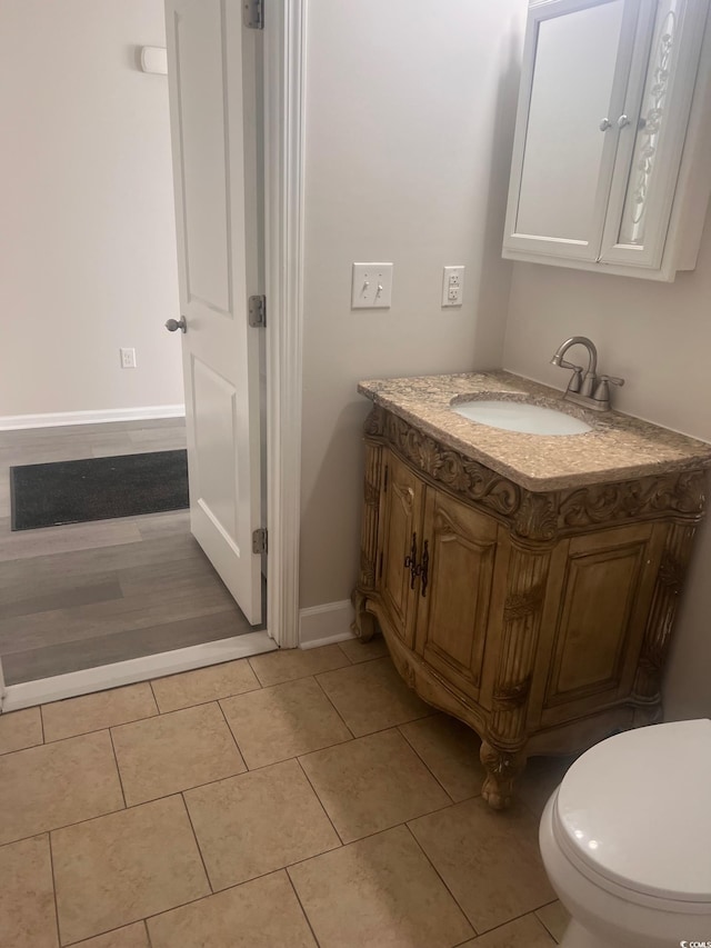 bathroom featuring tile patterned flooring, vanity, and toilet