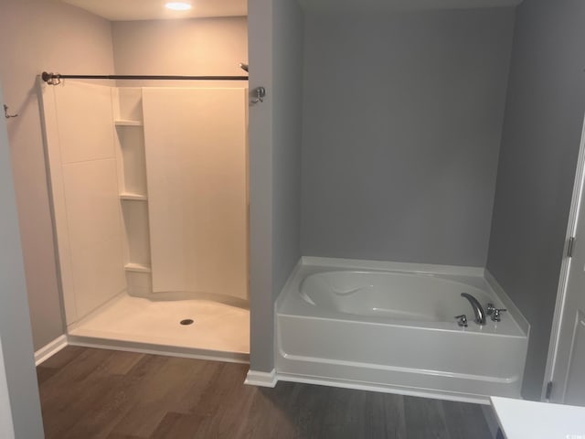 bathroom with hardwood / wood-style flooring and separate shower and tub