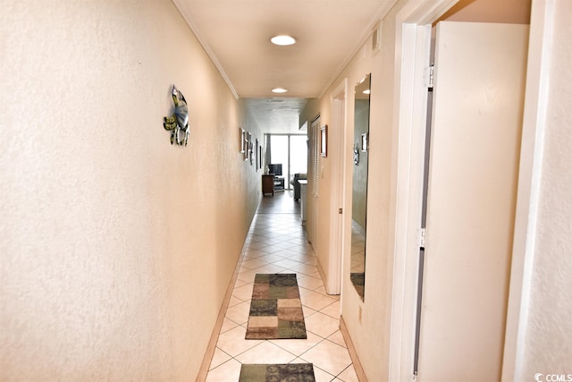 hallway featuring light tile floors and ornamental molding