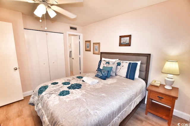 bedroom with light hardwood / wood-style floors, a closet, and ceiling fan