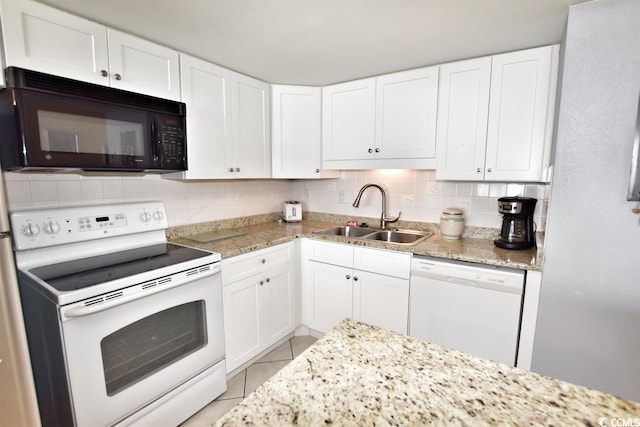 kitchen with tasteful backsplash, white appliances, light tile floors, sink, and white cabinets