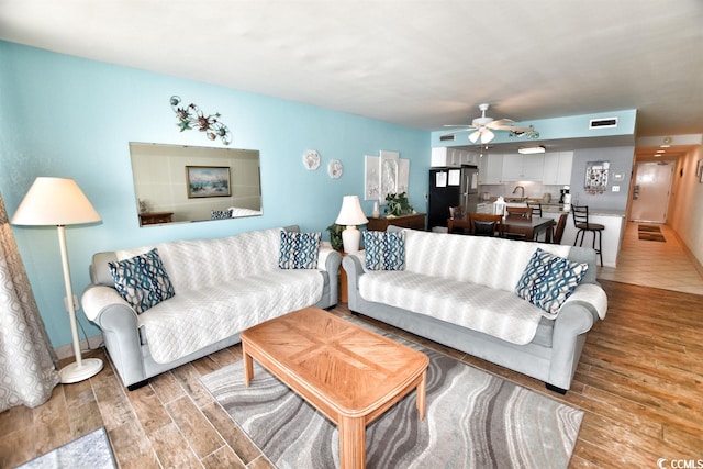 tiled living room featuring ceiling fan