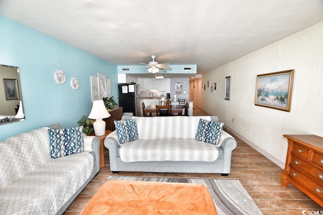 living room featuring ceiling fan and light hardwood / wood-style flooring