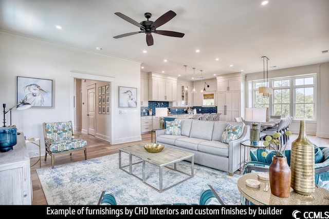 living room featuring crown molding, ceiling fan, and light hardwood / wood-style flooring