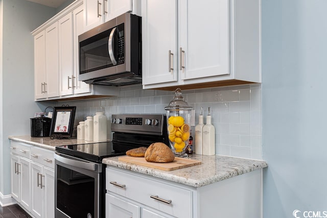 kitchen with stainless steel appliances, tasteful backsplash, and white cabinetry