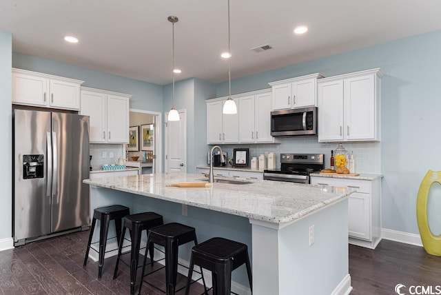 kitchen with dark wood finished floors, stainless steel appliances, visible vents, white cabinetry, and a sink