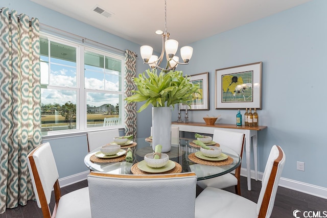 dining room featuring a notable chandelier, visible vents, baseboards, and wood finished floors